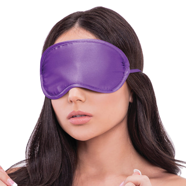 Woman wearing a satin blindfold on a white background